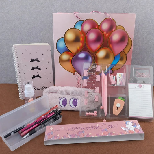 Stationery set with colorful balloons on a pink bag, notebooks, and stationery items on a brown surface.