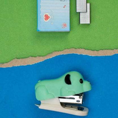 Green stapler and staples on a blue and green background
