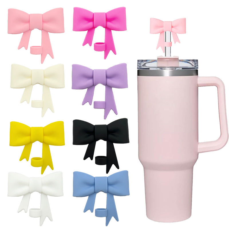 Pink tumbler with bow-shaped drink covers on a white background