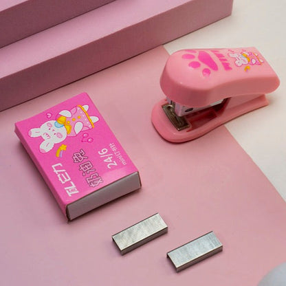 Pink stapler with cartoon design on a pink surface