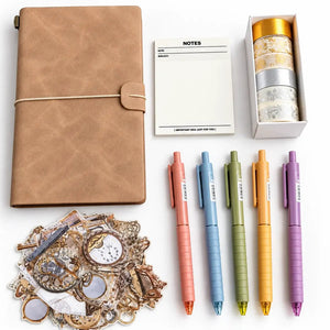A stationery gift set arranged on a white background, including a tan leather-look notebook with a rope closure, a small white notes pad, a box of patterned washi tapes, five colorful retractable pens in pink, blue, green, yellow, and purple, and a pile of decorative vintage-style stickers.
