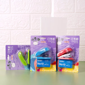 Three mini staplers with pins packaged in card boxes, displayed against a white background. Each stapler is in a different color: green, blue, and red.