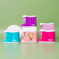 Four battery-operated automatic pencil sharpeners in various colors: blue, purple, white with a cartoon character, and pink.
