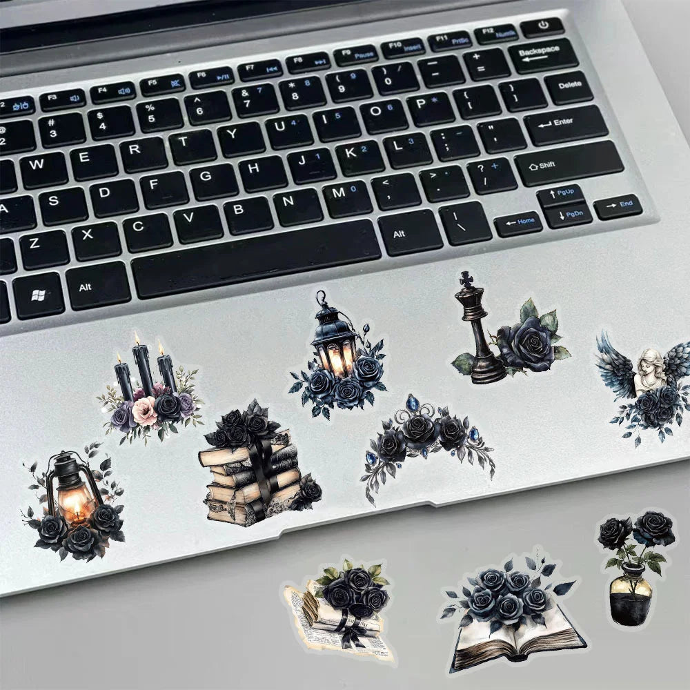 Decorative stickers with candles, books, and flowers on a laptop keyboard