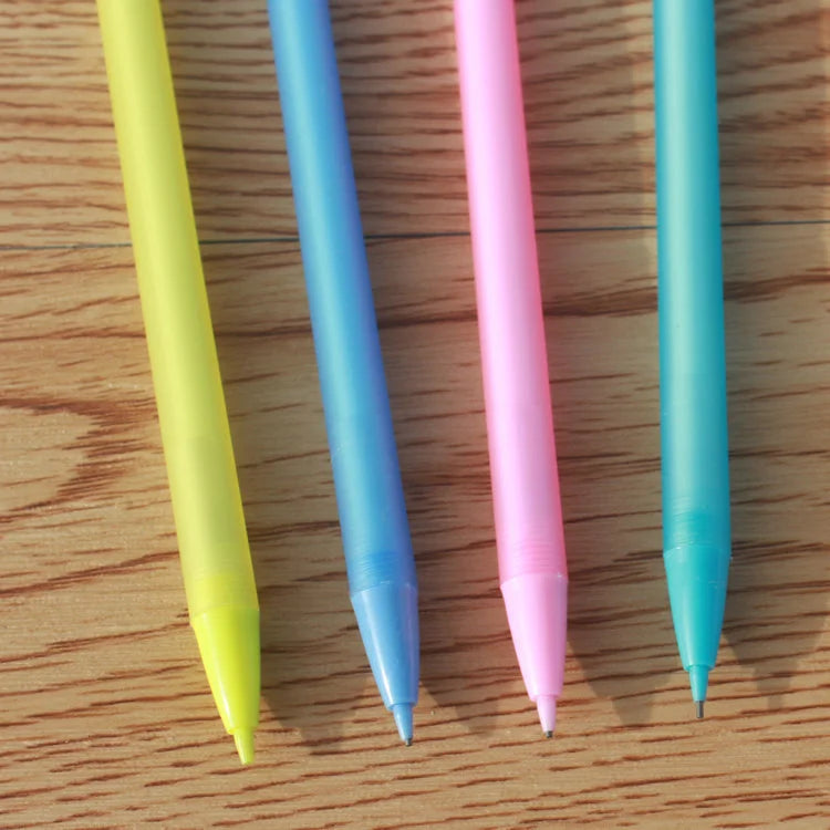 Four colorful pens (yellow, blue, pink, and light blue) on a wooden surface.