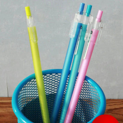 Colorful pens in a blue holder on a wooden surface with a gray background