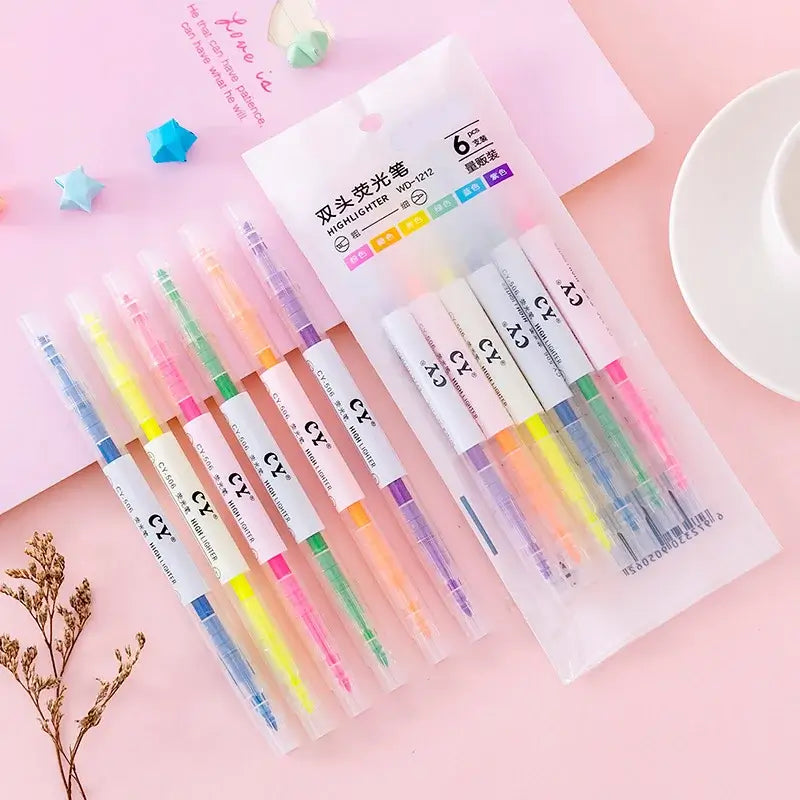 Set of colorful highlighters with a clear plastic packaging on a pink background