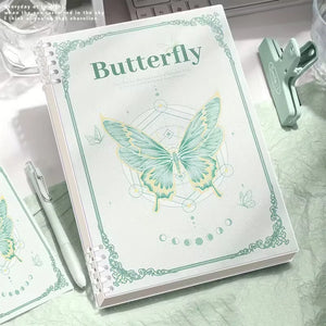 Notebook with butterfly design and text on a marble surface