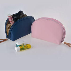 Two cosmetic bags, one blue and one pink, with various items on a white background.