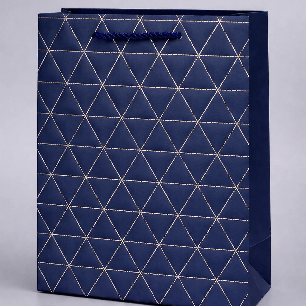 Navy blue gift bag with geometric white pattern on a light gray background
