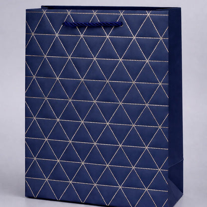 Navy blue gift bag with geometric white pattern on a light gray background
