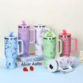 Set of colorful tumblers with floral designs on a light surface.