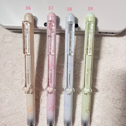 Four pens with different designs and colors on a textured surface