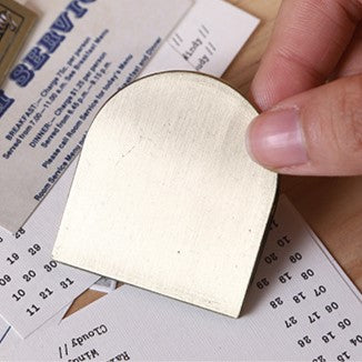 Hand holding a gold leaf over printed text