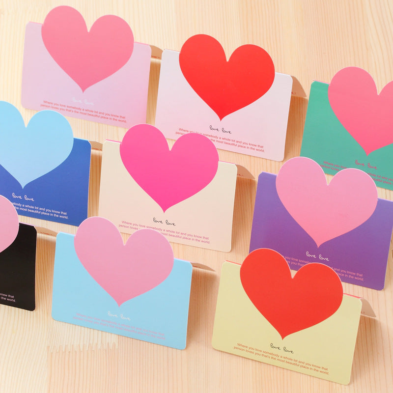 Colorful heart-shaped cards on a wooden surface