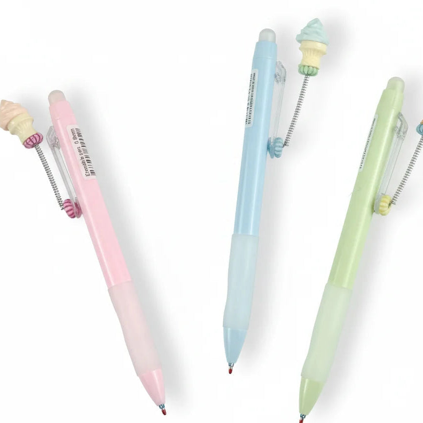 Three pastel-colored pens with small figurines on a white background