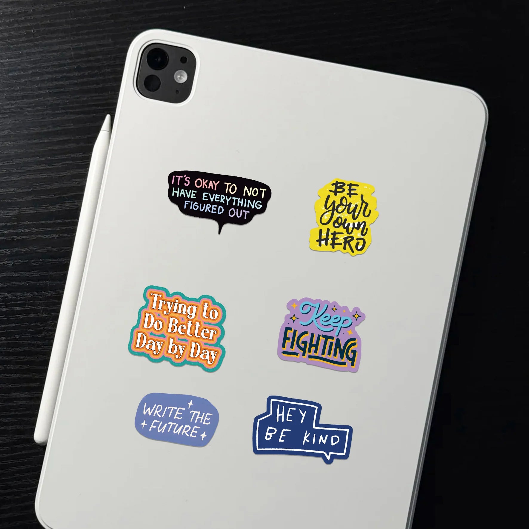 White tablet with motivational stickers on a dark surface