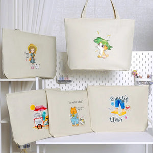 A collection of beige canvas shoulder bags with various colorful character prints.
