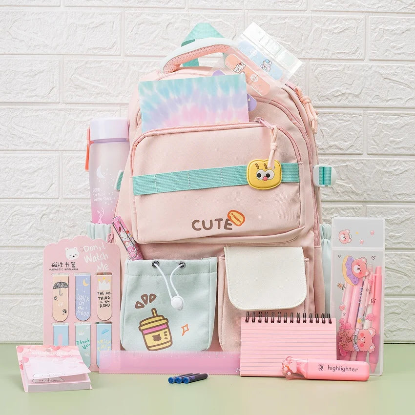 Pink backpack with stationery items on a light green surface and white textured wall background