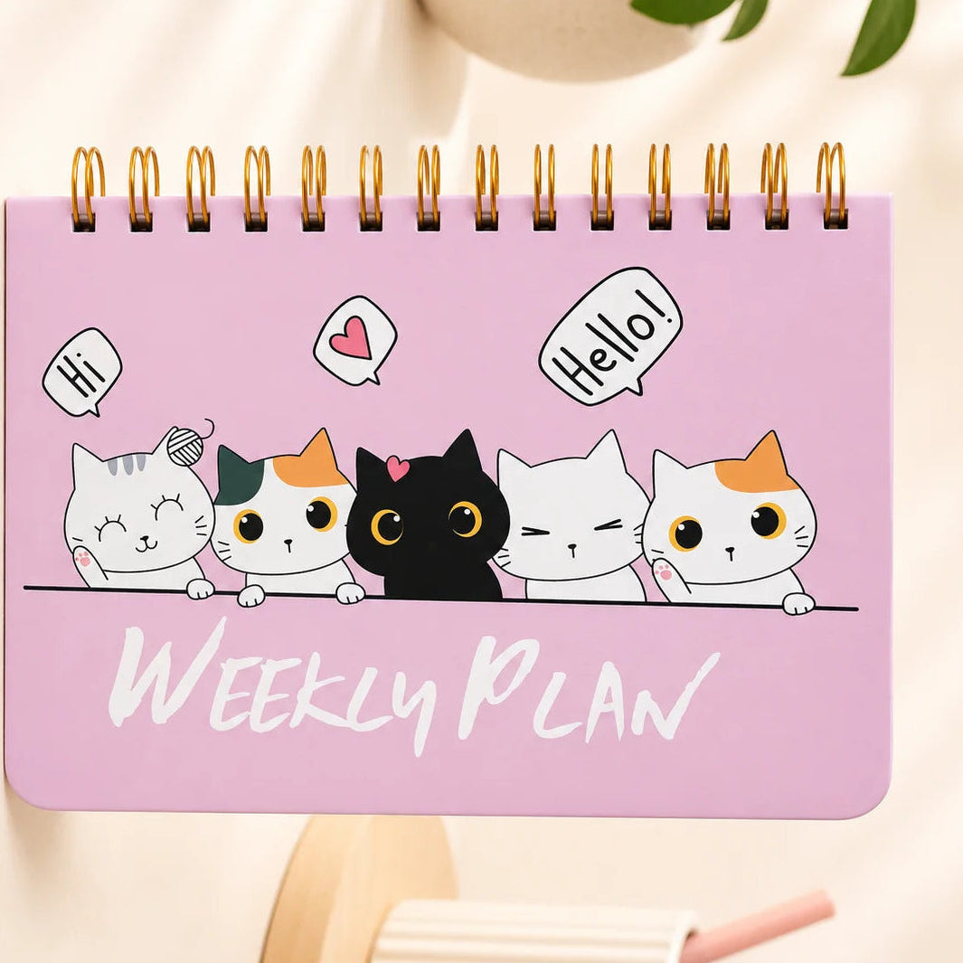 Pink weekly planner with cartoon cat designs on a light background