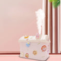 A white and transparent house-shaped fog humidifier with a rabbit 3D sticker, emitting a mist, placed in a room with a pink wall and curtains.