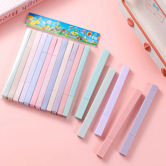 Set of pastel-colored markers with a colorful box on a pink background