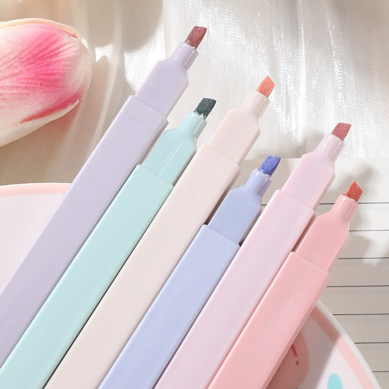 Set of pastel-colored markers on a light background