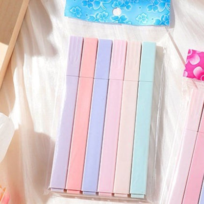 Set of pastel-colored markers in a clear plastic case on a light background