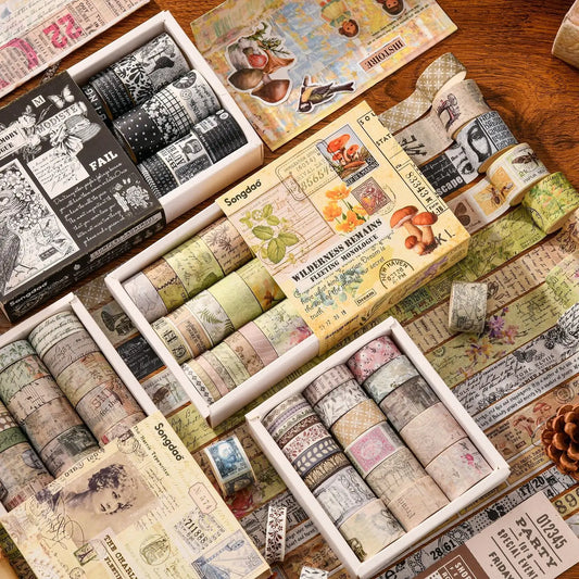 Collection of washi tape rolls in various designs and packaging on a wooden surface.