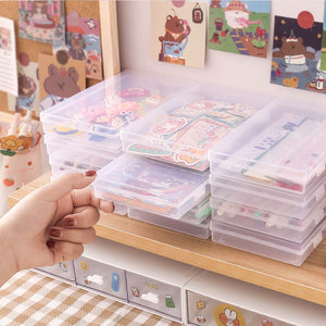 Stack of clear plastic storage boxes on a shelf with a hand reaching for one.