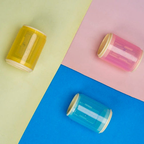 Three cylindrical glass jars with metal lids on a colorful background