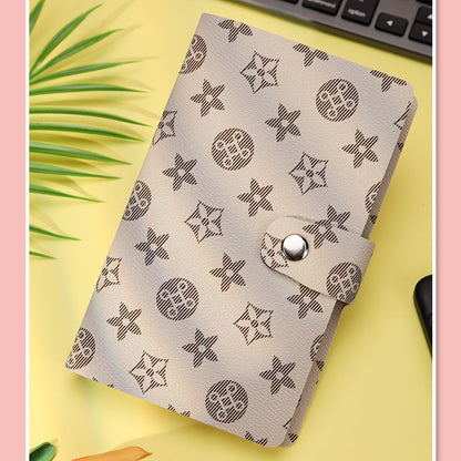 Patterned notebook cover on a yellow surface with a pink border