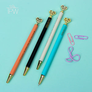 A set of mechanical pencils with heart-shaped tops and butterfly details, displayed in a variety of colors including black, white, orange, and blue. Accompanied by pink paper clips on a light blue background.