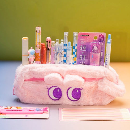 Pink pencil case with cartoon face design on a colorful background