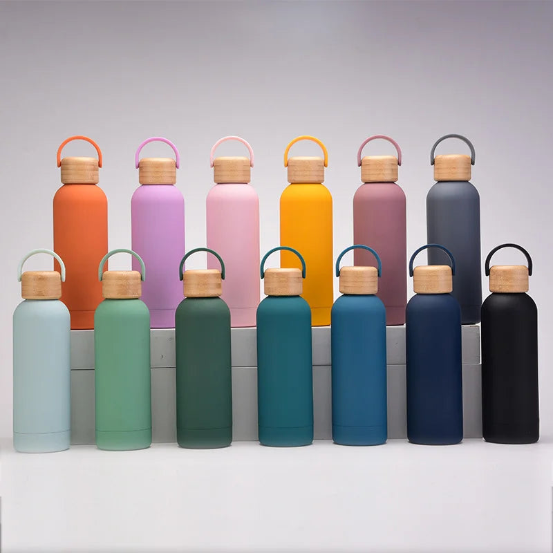 Row of colorful water bottles with wooden lids on a gray background