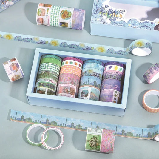 Set of colorful washi tape rolls in a box on a light gray surface.