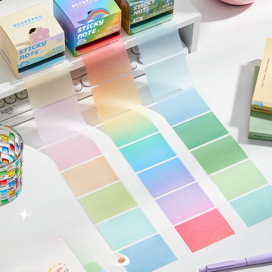 Colorful sticky notes with boxes and a pen on a white surface
