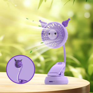 Purple cartoon-style fan with a clip on a wooden surface with a green blurred background