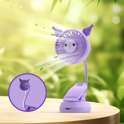 Purple cartoon-style fan with a clip on a wooden surface with a green blurred background