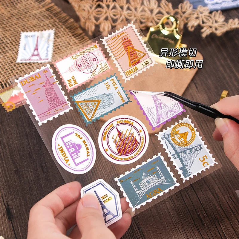 Collection of decorative stamps on a transparent sheet with hands holding it.