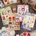 Collection of vintage-style postcard designs on a wooden surface with lace doilies.