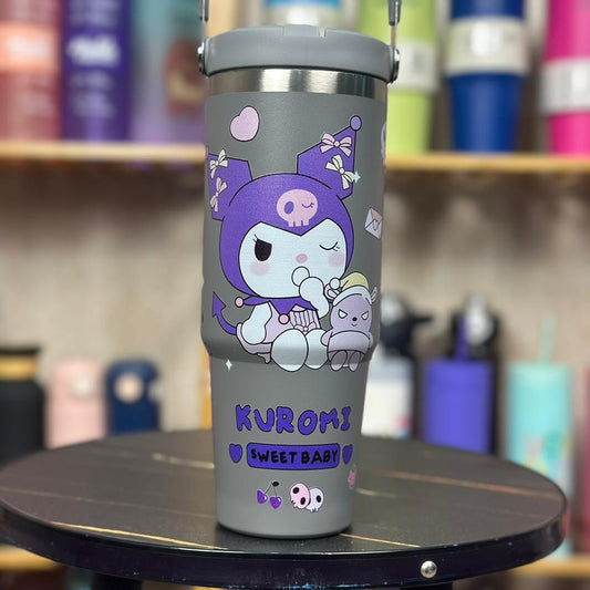 Gray tumbler with cartoon design and 'Kuromi Sweet Baby' text on a black stand, with colorful tumblers in the background.