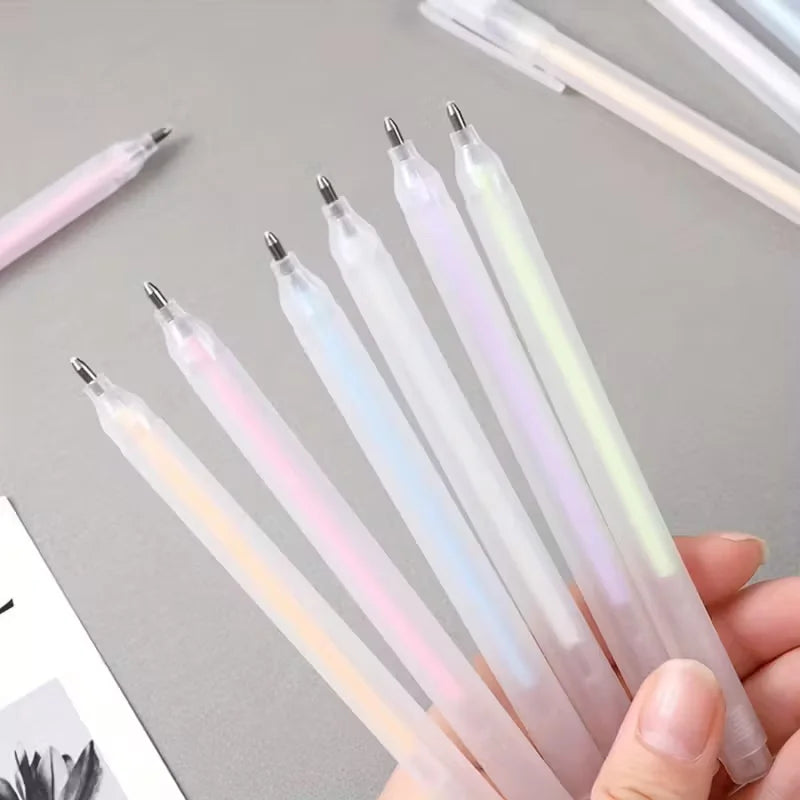 Set of translucent pens with colorful tips held by a hand on a light gray background