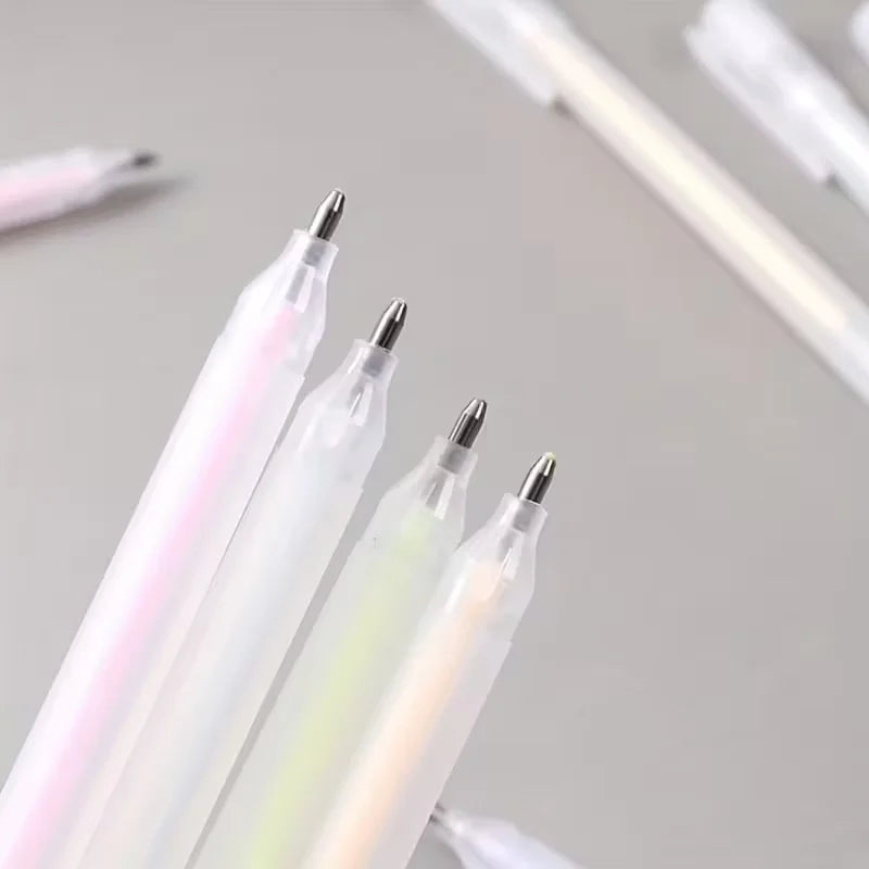Three iridescent pens with metallic tips on a light gray background