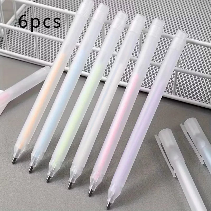 Set of six gradient pens on a gray surface with a white metal grid in the background.