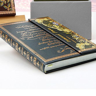 Decorative book with gold embossed text on a white surface