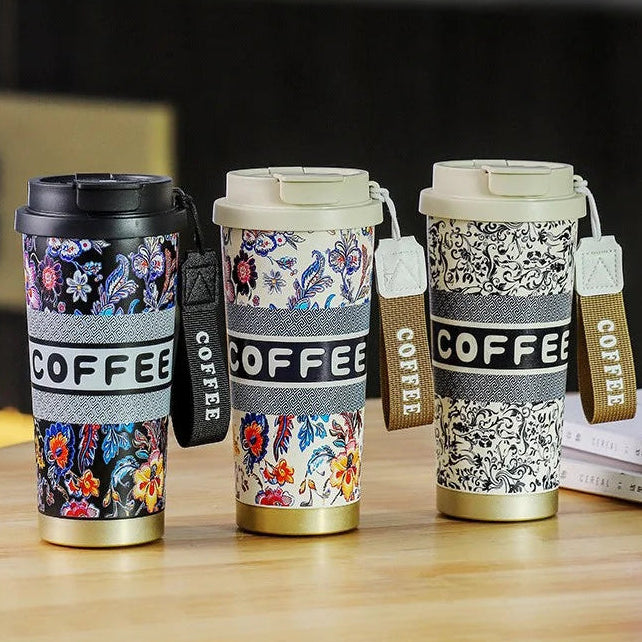 Three floral-patterned coffee tumblers with 'COFFEE' text on a wooden surface.