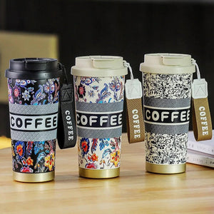 Three floral-patterned coffee tumblers with 'COFFEE' text on a wooden surface.