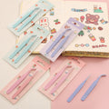 Set of tweezers in packaging with a colorful notebook in the background