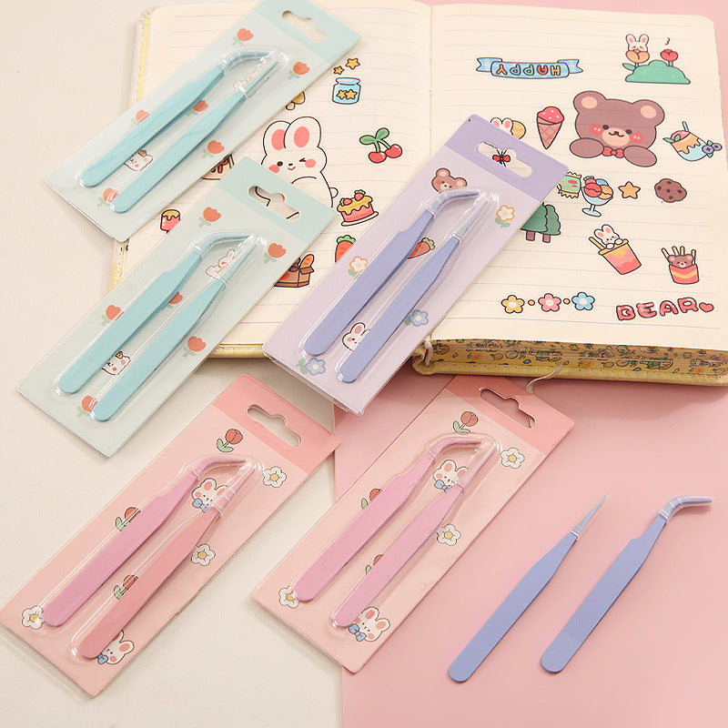 Set of tweezers in packaging with a colorful notebook in the background